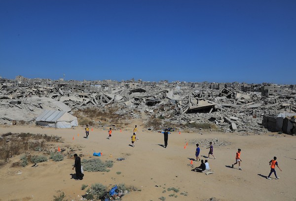 أطفال فلسطينيون نازحون يرتدون الزي الرياضي يشاركون في حصة تدريبية لكرة القدم في حي الشيخ رضوان بمدينة غزة، 16 يونيو/حزيران 2026. صورة: بلال أسامة