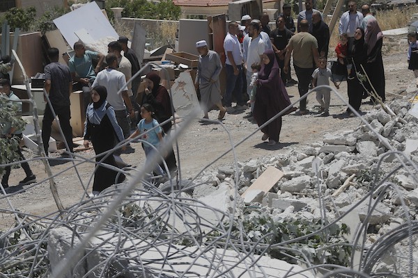 فلسطينيون يتفقدون أنقاض منزل وورشة نجارة هدمتهما جرافات الاحتلال في خربة قلقس جنوب الخليل، في 8 يونيو/حزيران 2026. تصوير: مأمون وزواز.