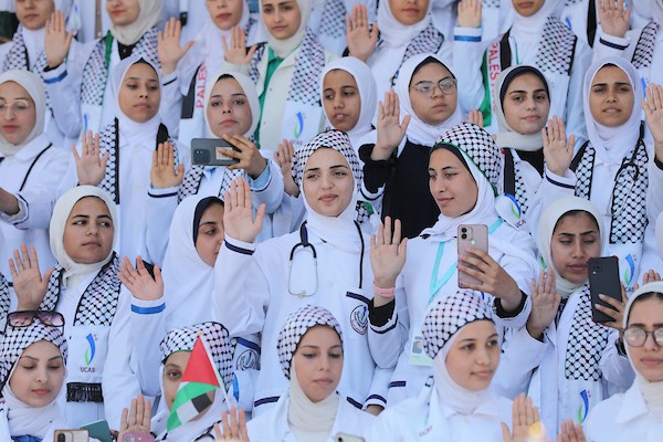 طلبة من كلية التمريض وعلوم الصحة في الكلية الجامعية للعلوم التطبيقية يرتدون المعطف الأبيض ويؤدون القسم بين أنقاض كليتهم المدمرة في غزة.صورة: بلال أسامة
