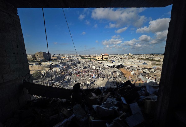 فلسطينيون يتفقدون الدمار الذي سببته غارة جوية إسرائيلية استهدفت خيام وملاجئ للنازحين في منطقة مواصي خان يونس، جنوب قطاع غزة، في 7 يونيو، 2026. تناثر الحطام والممتلكات الشخصية في جميع أنحاء المنطقة الرملية بينما كان السكان يبحثون بين حطام ملاجئهم المتضررة. (صورة:طارق محمد)