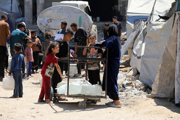 عائلات فلسطينية نازحة تملأ خزانات المياه قرب خيامها المتهالكة في مدينة غزة، وسط أزمة مياه مستمرة ونقص حاد في الخدمات الأساسية. تصوير: بلال أسامة
