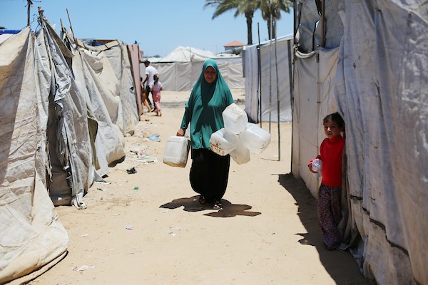نساء وأطفال فلسطينيون يصطفون للحصول على مياه الشرب في منطقة الزويدة بوسط قطاع غزة، في 18 يونيو/حزيران 2026. تصوير: حسن الجيدي
