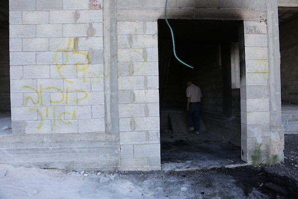 فلسطينيون يتفقدون منزلاً ومركبة محترقين عقب هجوم شنه مستوطنون في قرية بيت عمار شمال نابلس، 9 يونيو/حزيران 2026. تصوير: محمد ناصر
