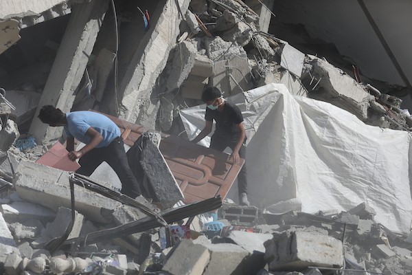 فلسطينيون يتفقدون الأضرار التي لحقت بمنازلهم عقب غارة جوية إسرائيلية استهدفت منزل عائلة درويش في مخيم النصيرات للاجئين وسط قطاع غزة. تصوير: حسن الجديدي