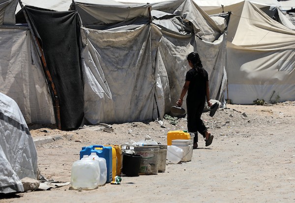 عائلات فلسطينية نازحة تملأ خزانات المياه قرب خيامها المتهالكة في مدينة غزة، وسط أزمة مياه مستمرة ونقص حاد في الخدمات الأساسية. تصوير: بلال أسامة