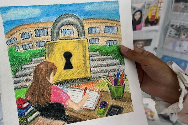 الفنانة الفلسطينية رنيم ناصر تعرض رسوماتها داخل خيمتها في دير البلح وسط قطاع غزة، موثّقةً بالألوان معاناة الحرب والنزوح. تصوير: يوسف أبو وطفة