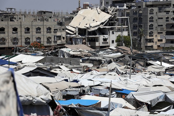 أطفال فلسطينيون يلعبون قرب خيام للنازحين وسط أنقاض المباني المدمرة غرب مدينة غزة، في ظل الحرّ وتدهور الأوضاع الإنسانية. تصوير: بلال أسامة