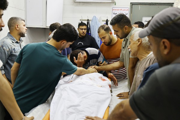 مشيعون يلتفون حول جثماني الممرض محمد الهبيل وطفله خلال جنازتهما في مستشفى الشفاء بمدينة غزة. تصوير: هادي داود