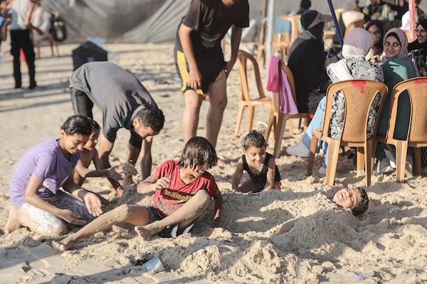 فلسطينيون يقضون بعض الوقت على شاطئ مخيم النصيرات وسط قطاع غزة، بحثًا عن ملاذ من موجة الحر الشديدة وتدهور أوضاع النزوح، في 25 يونيو/ حزيران 2026. تصوير: معز صالحي
