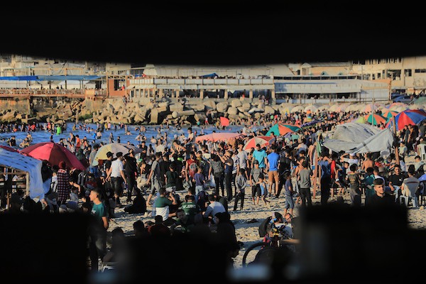 تعليق الصورة: فلسطينيون يتجمعون على شاطئ مدينة غزة في يوم حار، بحثاً عن متنفس وسط واقع إنساني وأمني صعب رغم الهدنة المعلنة. تصوير: بلال أسامة
