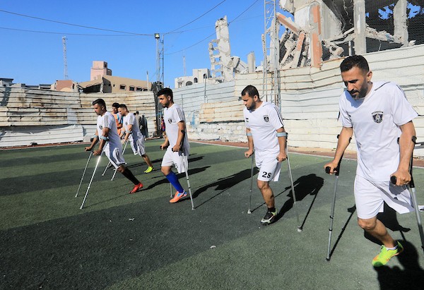 شباب فلسطينيون من مبتوري الأطراف يلعبون كرة القدم على ملعب متضرر في مدينة غزة، ضمن أنشطة لإعادة التأهيل والدعم النفسي، في 8 يونيو/حزيران 2026. تصوير: بلال أسامة.