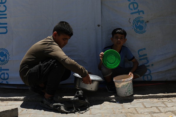 فلسطينيون نازحون، بينهم نساء وأطفال، يتجمعون للحصول على وجبات ساخنة وزّعها مطبخ خيري في مخيم النصيرات، في 13 يونيو/حزيران 2026.تصوير: حسن الجديدي