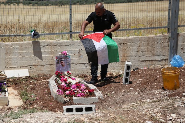 أب فلسطيني يضع باقة زهور على قبر نجله عماد هارون اشتية في قرية سالم قرب نابلس، في 2 يونيو/حزيران 2026. ووفق وزارة الصحة الفلسطينية، استشهد اشتية، البالغ من العمر 26 عاماً، برصاص القوات الإسرائيلية قرب جدار الفصل بين الضفة الغربية والقدس في 31 مايو/أيار.  تصوير: محمد ناصر