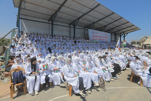 طلبة من كلية التمريض وعلوم الصحة في الكلية الجامعية للعلوم التطبيقية يرتدون المعطف الأبيض ويؤدون القسم بين أنقاض كليتهم المدمرة في غزة.صورة: بلال أسامة