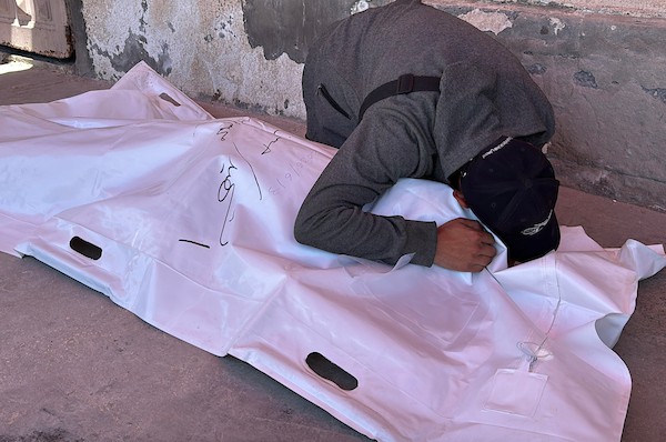 تجمّع فلسطينيون حول جثمان حسن سلامة في مستشفى شهداء الأقصى بدير البلح، وسط قطاع غزة، في 3 يونيو/حزيران 2026، بعد التعرّف عليه عقب استشهاده في غارة جوية إسرائيلية بطائرة مسيّرة على شارع صلاح الدين قرب وادي غزة وسط القطاع. صورة: أحمد إبراهيم