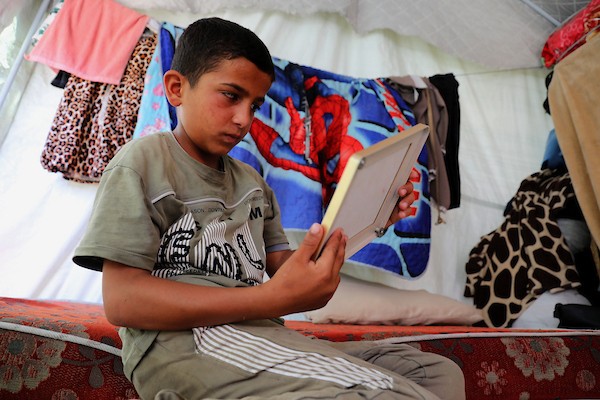 الطفل محمد الجرجاوي، 12 عاماً، يجلس داخل خيمة مع عائلته النازحة في مدينة غزة، بعد أن فقد إحدى عينيه أثناء فراره من شمال القطاع. تصوير: بلال أسامة