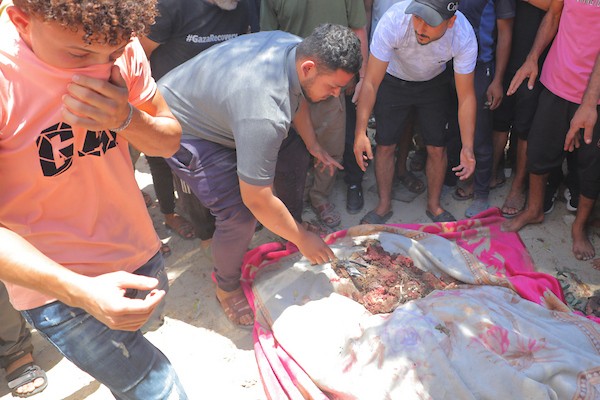 يتجمع فلسطينيون حول جثماني الشهيدين أحمد ومحمود وليد أبو هين، اللذين ارتقيا في غارة إسرائيلية استهدفت مخيم النصيرات. تصوير: حسن الجديدي