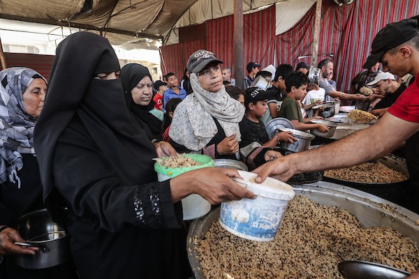 نازحون فلسطينيون يتجمعون لتلقي وجبات مجانية في مخيم النصيرات وسط قطاع غزة، حيث تتفاقم أزمة الغذاء مع تراجع عمليات الإغاثة، في 6 يونيو/حزيران 2026. صورة: معز صالحي.