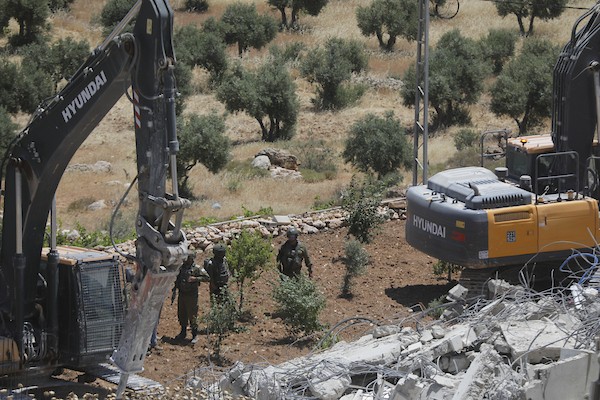 فلسطينيون يتفقدون أنقاض منزل وورشة نجارة هدمتهما جرافات الاحتلال في خربة قلقس جنوب الخليل، في 8 يونيو/حزيران 2026. تصوير: مأمون وزواز.