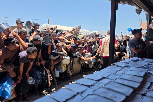 نازحون فلسطينيون ينتظرون الحصول على وجبات ساخنة من مطبخ خيري في خان يونس، جنوب قطاع غزة، وسط نقص حاد في الإمدادات الغذائية. تصوير: طارق محمد