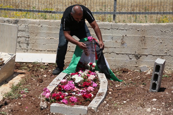 أب فلسطيني يضع باقة زهور على قبر نجله عماد هارون اشتية في قرية سالم قرب نابلس، في 2 يونيو/حزيران 2026. ووفق وزارة الصحة الفلسطينية، استشهد اشتية، البالغ من العمر 26 عاماً، برصاص القوات الإسرائيلية قرب جدار الفصل بين الضفة الغربية والقدس في 31 مايو/أيار.  تصوير: محمد ناصر