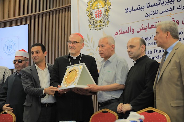 الكاردينال بييرباتيستا بيتسابالا، بطريرك القدس اللاتيني، يغرس شجرة زيتون بعد حضوره حوارًا بين الأديان في جامعة الأزهر بمدينة غزة، في 22 يونيو/حزيران 2026. (صورة: بلال أسامة)