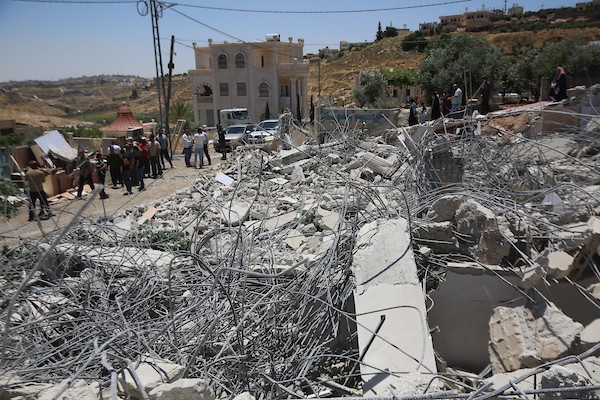 فلسطينيون يتفقدون أنقاض منزل وورشة نجارة هدمتهما جرافات الاحتلال في خربة قلقس جنوب الخليل، في 8 يونيو/حزيران 2026. تصوير: مأمون وزواز.