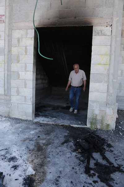 فلسطينيون يتفقدون منزلاً ومركبة محترقين عقب هجوم شنه مستوطنون في قرية بيت عمار شمال نابلس، 9 يونيو/حزيران 2026. تصوير: محمد ناصر