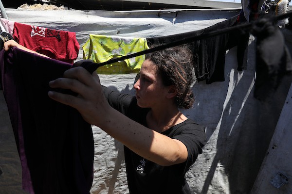 الفتاة الفلسطينية أشجان السوسي داخل خيمة تؤوي أسرتها النازحة غرب مدينة غزة، حيث تعاني من مرض جلدي تفاقم بفعل الحرّ وظروف النزوح القاسية. تصوير: بلال أسامة