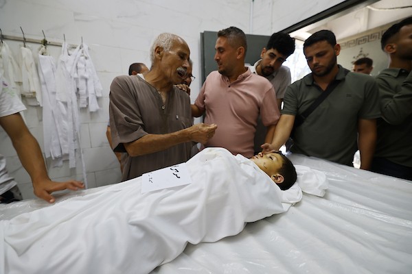 مشيعون يلتفون حول جثماني الممرض محمد الهبيل وطفله خلال جنازتهما في مستشفى الشفاء بمدينة غزة. تصوير: هادي داود