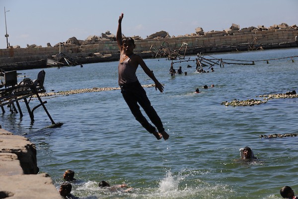 أطفال فلسطينيون وعائلات نازحة يقضون وقتًا على شاطئ غزة، حيث تحوّل الساحل إلى مأوى مؤقت وسط الخيام المكتظة، 14 يونيو/حزيران 2026. تصوير: بلال أسامة