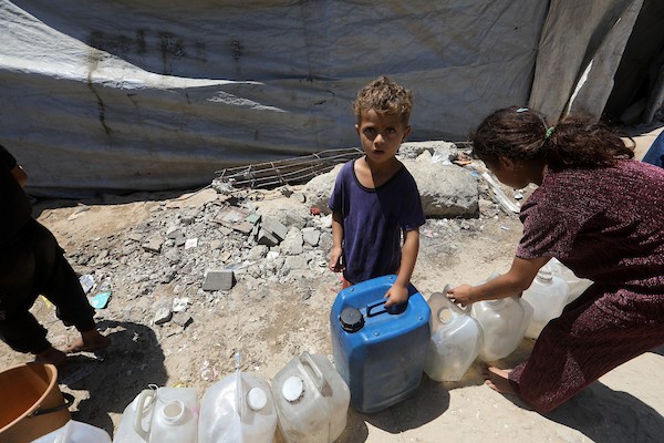 عائلات فلسطينية نازحة تملأ خزانات المياه قرب خيامها المتهالكة في مدينة غزة، وسط أزمة مياه مستمرة ونقص حاد في الخدمات الأساسية. تصوير: بلال أسامة