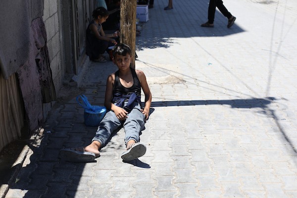فلسطينيون نازحون، بينهم نساء وأطفال، يتجمعون للحصول على وجبات ساخنة وزّعها مطبخ خيري في مخيم النصيرات، في 13 يونيو/حزيران 2026.تصوير: حسن الجديدي