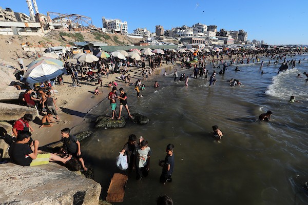 تعليق الصورة: فلسطينيون يتجمعون على شاطئ مدينة غزة في يوم حار، بحثاً عن متنفس وسط واقع إنساني وأمني صعب رغم الهدنة المعلنة. تصوير: بلال أسامة