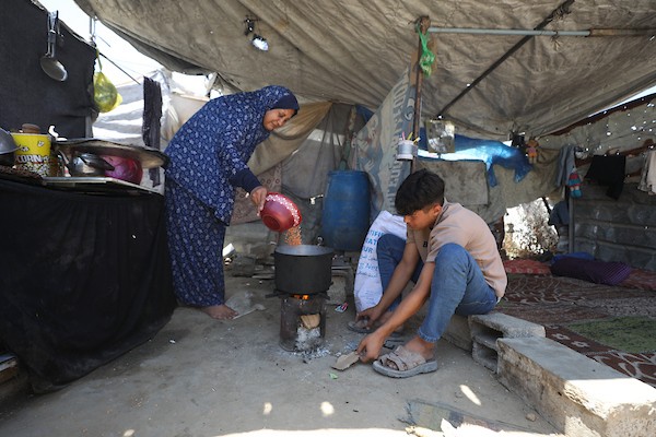 أطفال فلسطينيون نازحون يحاولون التخفيف من حرارة الصيف داخل خيمة مهترئة في مخيم النصيرات وسط قطاع غزة. تصوير: حسن الجديدي