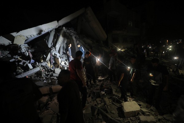 فلسطينيون يتفقدون الأضرار التي لحقت بمنازلهم عقب غارة جوية إسرائيلية استهدفت منزل عائلة درويش في مخيم النصيرات للاجئين وسط قطاع غزة. تصوير: حسن الجديدي