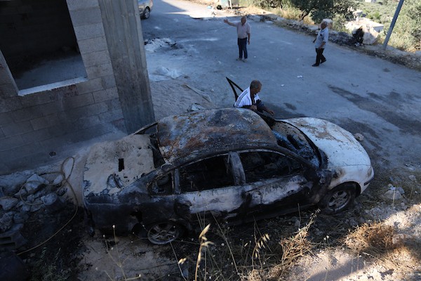 فلسطينيون يتفقدون منزلاً ومركبة محترقين عقب هجوم شنه مستوطنون في قرية بيت عمار شمال نابلس، 9 يونيو/حزيران 2026. تصوير: محمد ناصر