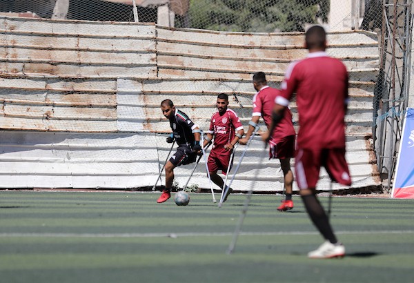 مبتورو الأطراف في غزة يعودون إلى الملعب برسالة صمود واندماج  شارك لاعبون فلسطينيون من مبتوري الأطراف، أصيبوا خلال الحرب في قطاع غزة، في مباراة رمزية أُقيمت على ملعب فلسطين بمدينة غزة، يوم 28 يوليو/تموز 2026، في مبادرة جمعت بين الرياضة والدعم الإنساني.  ونُظمت المباراة بالتعاون مع مؤسسة «دنيز فنيري»، بهدف دعم الرياضيين من مبتوري الأطراف وتعزيز دمج الأشخاص ذوي الإعاقة في المجتمع من خلال الرياضة، في ظل الظروف الصعبة التي يعيشها سكان القطاع.  وحملت عودة اللاعبين إلى أرض الملعب دلالة تتجاوز المنافسة الرياضية، إذ عكست تمسكهم بالحياة وقدرتهم على تجاوز آثار الإصابة واستعادة مساحة من النشاط والأمل، رغم التحديات الجسدية والنفسية التي خلّفتها الحرب.  وسعت المبادرة إلى تسليط الضوء على احتياجات المصابين من ذوي الإعاقة، وفتح المجال أمامهم لمواصلة ممارسة الرياضة والمشاركة الفاعلة في المجتمع.  تعليق الصورة: لاعبون فلسطينيون من مبتوري الأطراف يشاركون في مباراة رمزية على ملعب فلسطين بمدينة غزة، 28 يوليو/تموز 2026. تصوير: بلال أسامة.