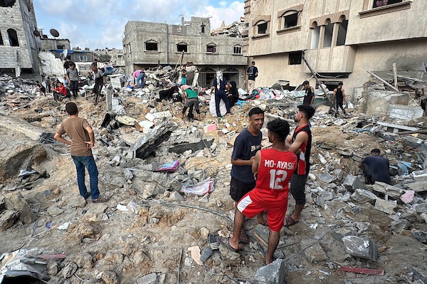 يتفقد فلسطينيون المباني المدمرة في موقع غارة جوية إسرائيلية على مخيم المغازي للاجئين، وسط قطاع غزة، يوم الجمعة 24 يوليو/تموز 2026. تصوير: أحمد إبراهيم