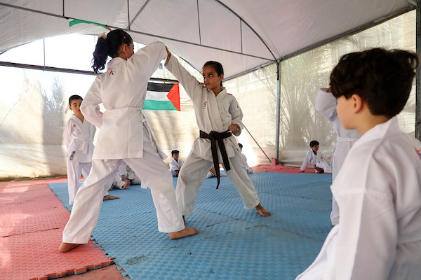 أطفال يتدربون على رياضة الكاراتيه داخل خيمة أقامها المدرب خليل عياد في دير البلح وسط قطاع غزة، في 6 تموز/يوليو 2026.تصوير: بلال أسامة