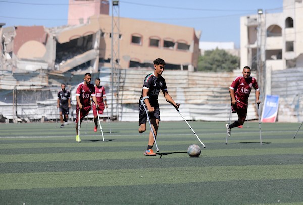 مبتورو الأطراف في غزة يعودون إلى الملعب برسالة صمود واندماج  شارك لاعبون فلسطينيون من مبتوري الأطراف، أصيبوا خلال الحرب في قطاع غزة، في مباراة رمزية أُقيمت على ملعب فلسطين بمدينة غزة، يوم 28 يوليو/تموز 2026، في مبادرة جمعت بين الرياضة والدعم الإنساني.  ونُظمت المباراة بالتعاون مع مؤسسة «دنيز فنيري»، بهدف دعم الرياضيين من مبتوري الأطراف وتعزيز دمج الأشخاص ذوي الإعاقة في المجتمع من خلال الرياضة، في ظل الظروف الصعبة التي يعيشها سكان القطاع.  وحملت عودة اللاعبين إلى أرض الملعب دلالة تتجاوز المنافسة الرياضية، إذ عكست تمسكهم بالحياة وقدرتهم على تجاوز آثار الإصابة واستعادة مساحة من النشاط والأمل، رغم التحديات الجسدية والنفسية التي خلّفتها الحرب.  وسعت المبادرة إلى تسليط الضوء على احتياجات المصابين من ذوي الإعاقة، وفتح المجال أمامهم لمواصلة ممارسة الرياضة والمشاركة الفاعلة في المجتمع.  تعليق الصورة: لاعبون فلسطينيون من مبتوري الأطراف يشاركون في مباراة رمزية على ملعب فلسطين بمدينة غزة، 28 يوليو/تموز 2026. تصوير: بلال أسامة.
