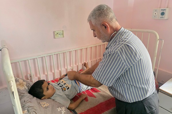 الفلسطينية إيمان أبو جامع تجلس إلى جانب طفلها ياسر عرفات، البالغ ست سنوات، أثناء تلقيه العلاج من سوء التغذية في مجمع ناصر الطبي بخان يونس، جنوب قطاع غزة، في 8 يوليو/تموز 2026. وتقول الأم إنها فقدت زوجها وابنًا آخر بسبب مضاعفات سوء التغذية. تصوير: طارق محمد