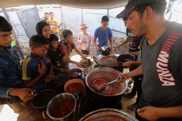 في الثاني من يوليو/تموز 2026، تجمع فلسطينيون نازحون، بينهم نساء وأطفال، لتلقي وجبات طعام من مركز توزيع خيري شرق مدينة غزة.صورة: بلال أسامة