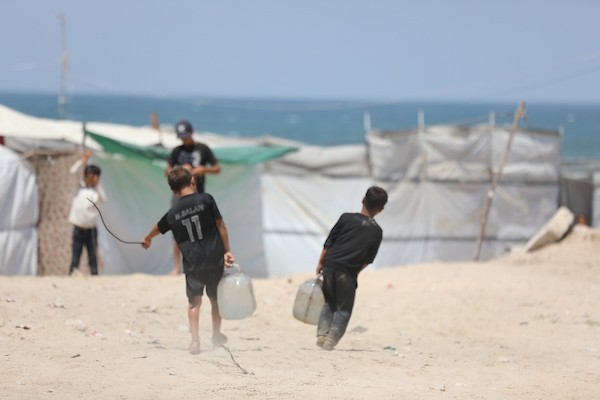 فلسطينيون نازحون يعيشون داخل خيام مؤقتة مكتظة على طول شاطئ مدينة غزة، في 9 يوليو/تموز 2026، وسط حرارة صيفية مرتفعة ونقص في المياه النظيفة والخدمات الأساسية، بعد فرارهم من مناطق متفرقة من القطاع. (تصوير: بلال أسامة)