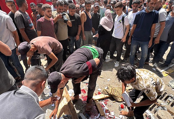 تجمّع فلسطينيون في موقع غارة جوية إسرائيلية قرب مدخل مستشفى شهداء الأقصى في دير البلح، وسط قطاع غزة، بينما كانت فرق الإسعاف تُجلي الجرحى من الموقع، في 25 يوليو/تموز 2026.صورة: أحمد إبراهيم