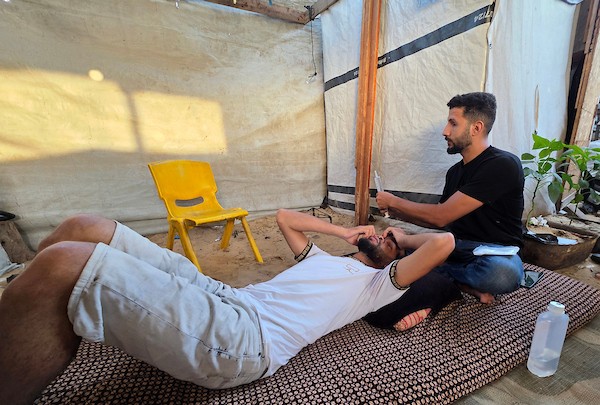 الشقيقان محمد دبور وموسى دبور داخل خيمة للنازحين في خان يونس، جنوب قطاع غزة، في 9 يوليو/تموز 2026. فقد محمد بصره بالكامل، فيما فقد موسى عينه اليسرى، إثر حادثة قرب مركز لتوزيع المساعدات في يوليو/تموز 2025 أودت بحياة شقيقهما حسين.(تصوير: طارق محمد)