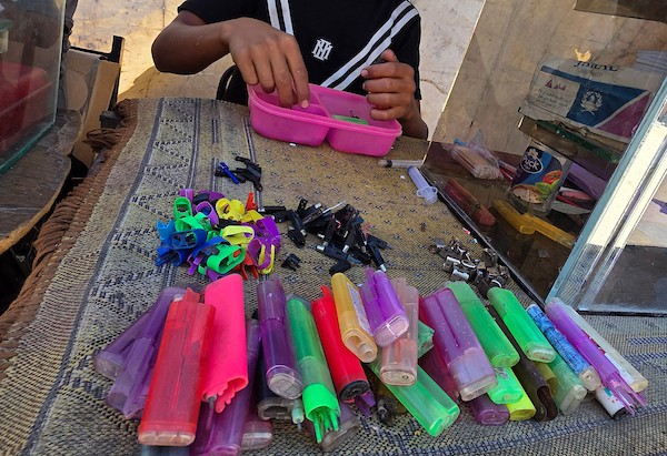 عامل فلسطيني يصلح ولاعات غاز مستعملة داخل ورشة في خان يونس، جنوب قطاع غزة، في 28 يوليو/تموز 2026. تصوير: طارق محمد.