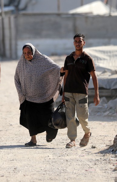 يحمل فلسطينيون نازحون أمتعتهم أثناء مغادرتهم خيامهم في حي الزيتون بمدينة غزة في 18 يوليو/تموز 2026. صورة: بلال أسامة