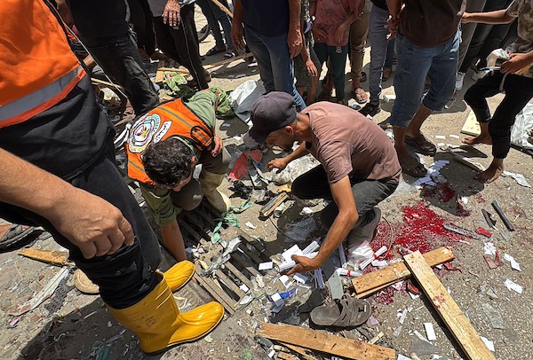 تجمّع فلسطينيون في موقع غارة جوية إسرائيلية قرب مدخل مستشفى شهداء الأقصى في دير البلح، وسط قطاع غزة، بينما كانت فرق الإسعاف تُجلي الجرحى من الموقع، في 25 يوليو/تموز 2026.صورة: أحمد إبراهيم