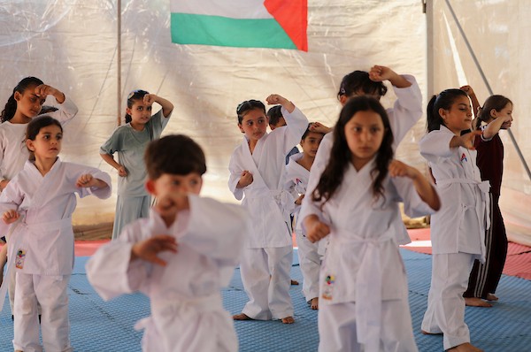 أطفال يتدربون على رياضة الكاراتيه داخل خيمة أقامها المدرب خليل عياد في دير البلح وسط قطاع غزة، في 6 تموز/يوليو 2026.تصوير: بلال أسامة